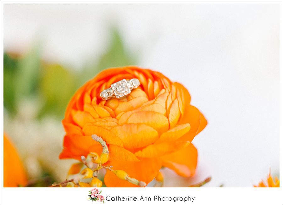 vintage engagement ring sitting on an orange flower