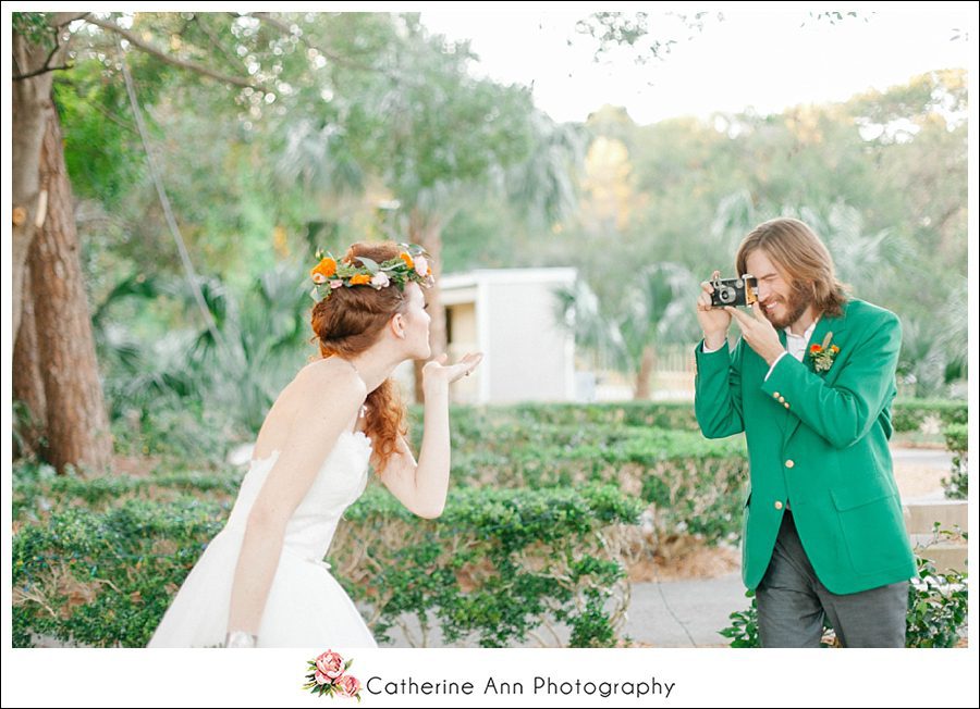 fun portrait of a groom taking his brides photo with a vintage camera