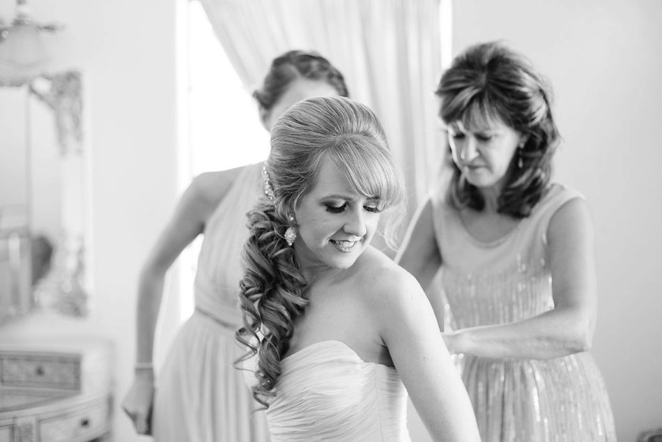 brides mom and sister helping her get dressed 