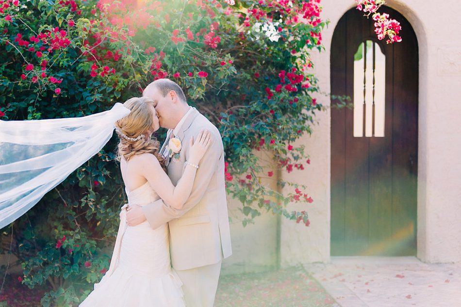 bride and groom kissing in front of azaleas in sarasota florida