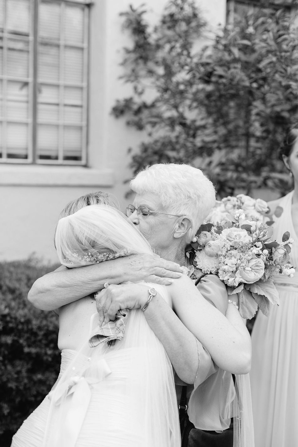 candid moment of bride getting a kiss from her grandmother 