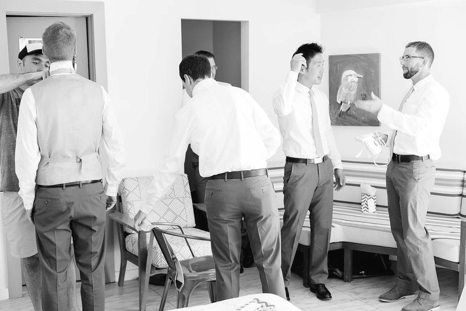 Groomsmen hanging out in the room getting ready. Destination wedding at the Postcard Inn on the Beach by Catherine Ann Photography