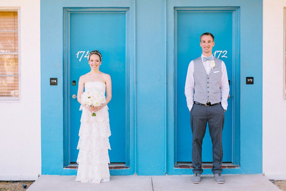 fun wedding photo idea of couple standing in front of colorful doors. Destination wedding at the Postcard Inn on the Beach by Catherine Ann Photography