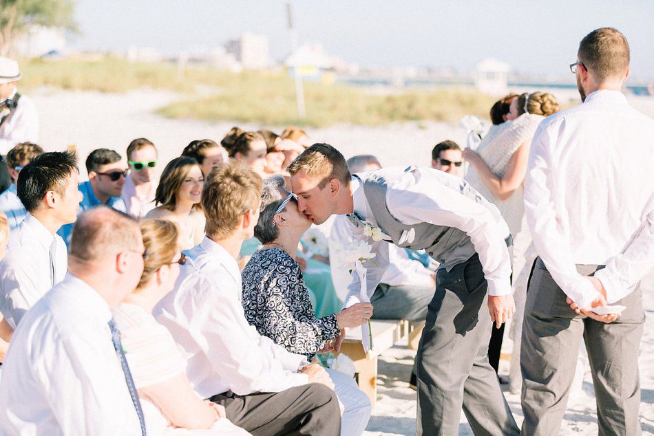 Groom giving his mom a kiss during the ceremony. Destination wedding at the Postcard Inn on the Beach by Catherine Ann Photography