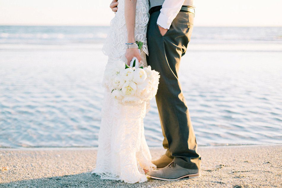Creative wedding photography inspiration. Soft beach wedding portrait of the bride and groom with the ocean behind them by Catherine Ann Photography