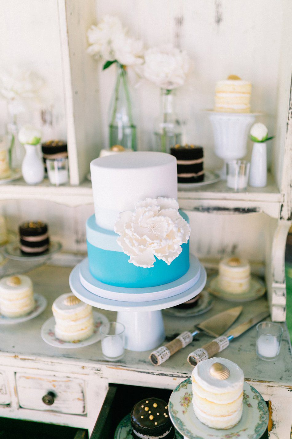 Blue and white wedding cake with giant flower created by Hands on Sweets in Tampa FL. Destination wedding at the Postcard Inn on the Beach by Catherine Ann Photography