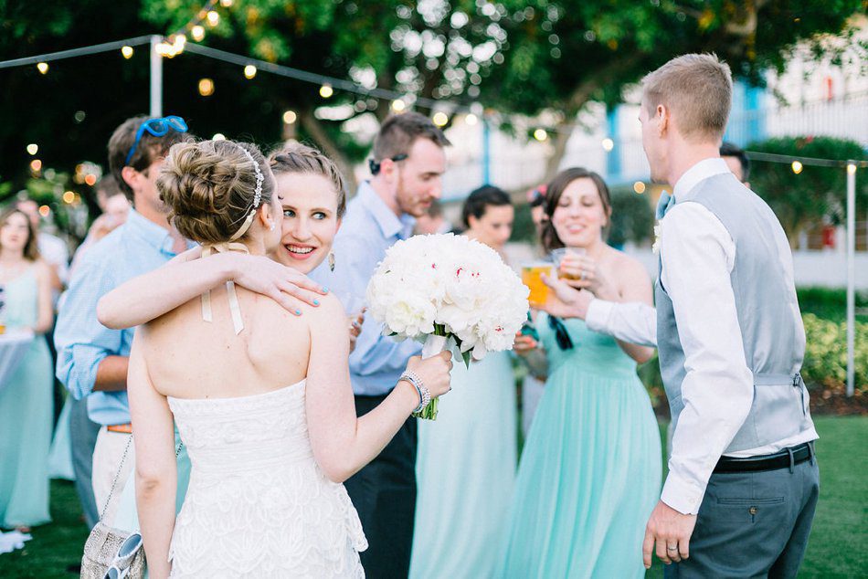 Candid wedding photos of guests hugging the bride. Destination wedding at the Postcard Inn on the Beach by Catherine Ann Photography