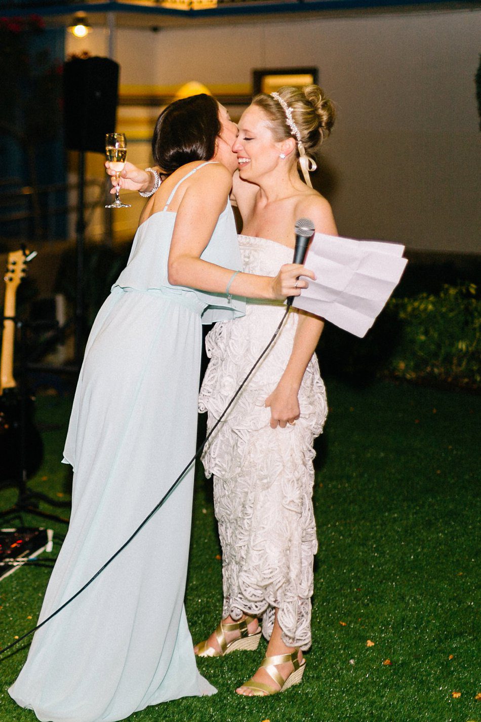 Bride and maid of honor hugging after speeches. Destination wedding at the Postcard Inn on the Beach by Catherine Ann Photography