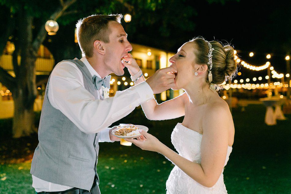 Photo of bride and groom feeding each other cake. Destination wedding at the Postcard Inn on the Beach by Catherine Ann Photography