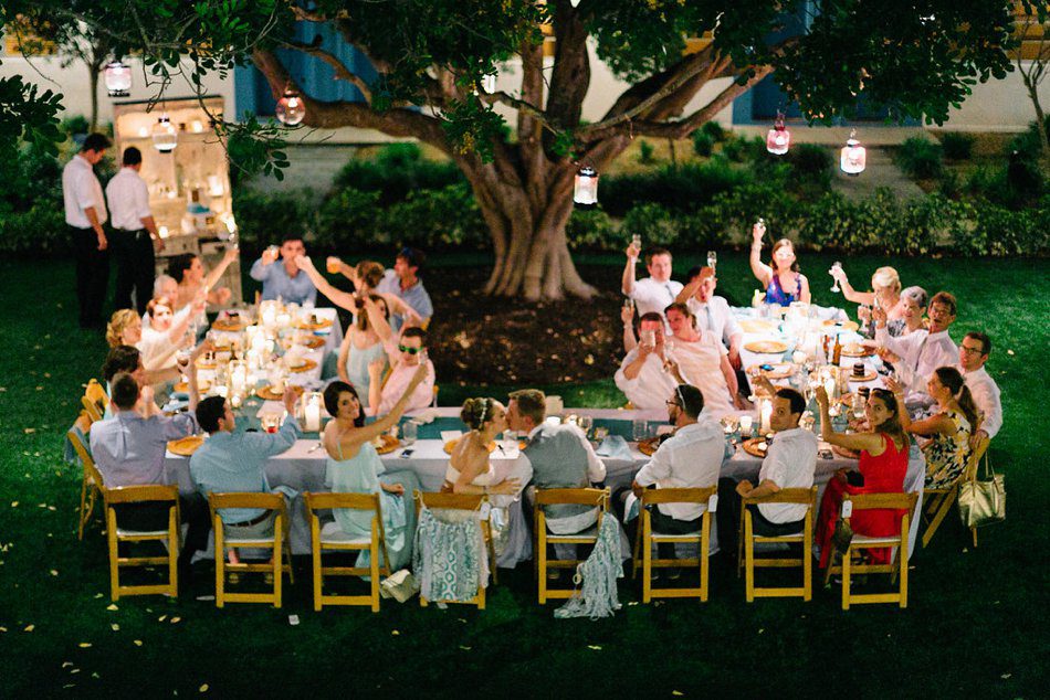 Best wedding reception photos of couple kissing and guests cheering. Destination wedding at the Postcard Inn on the Beach by Catherine Ann Photography