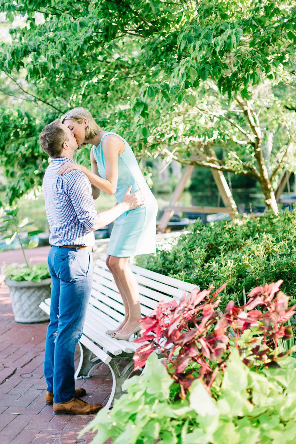 girl standing on a bench kissing her fiance