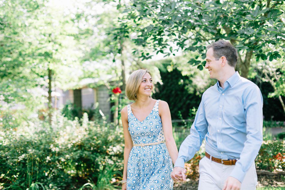 couple walking and holding hands in a garden