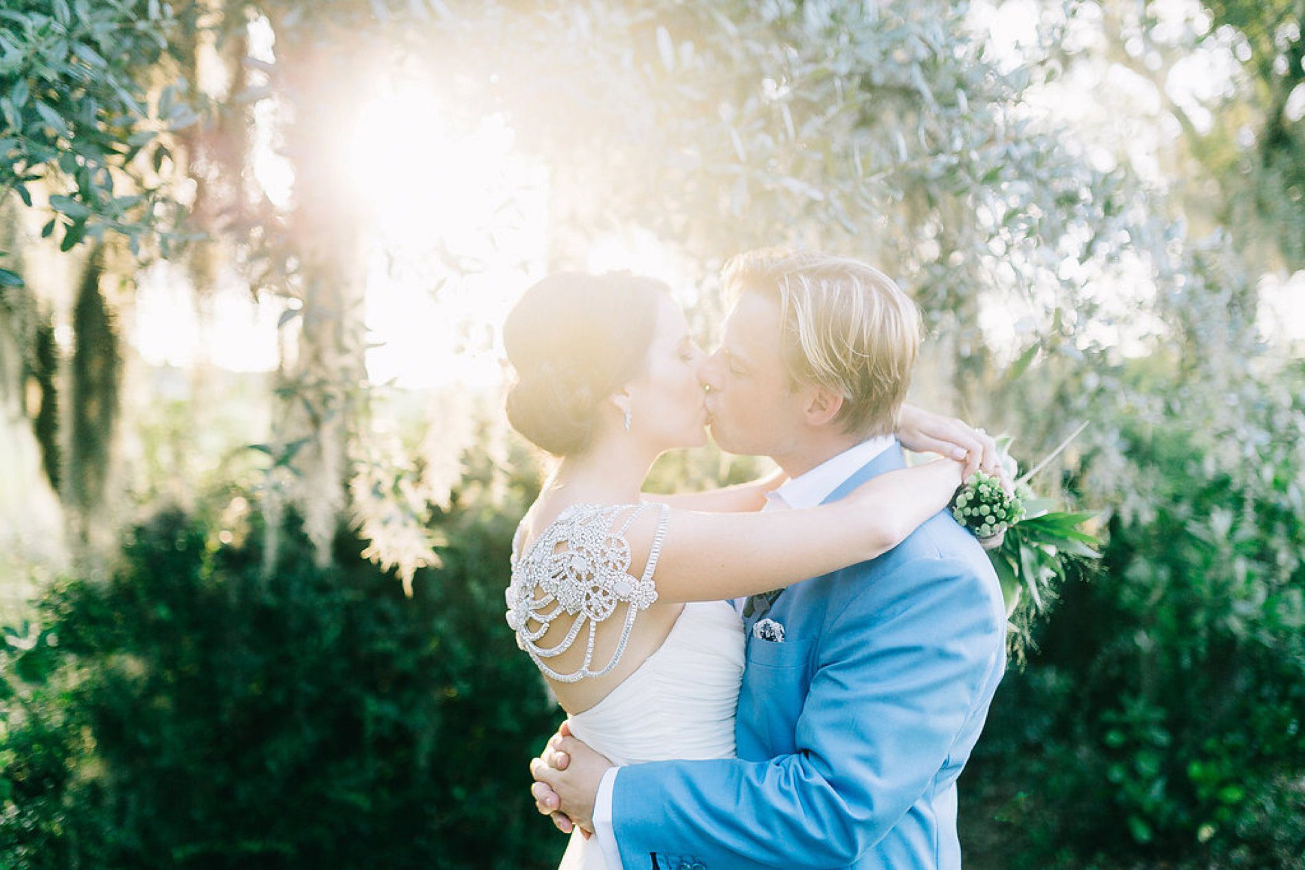 Romantic wedding photo with sunflare and spanish moss. Destination Charleston wedding photos by Catherine Ann Photography