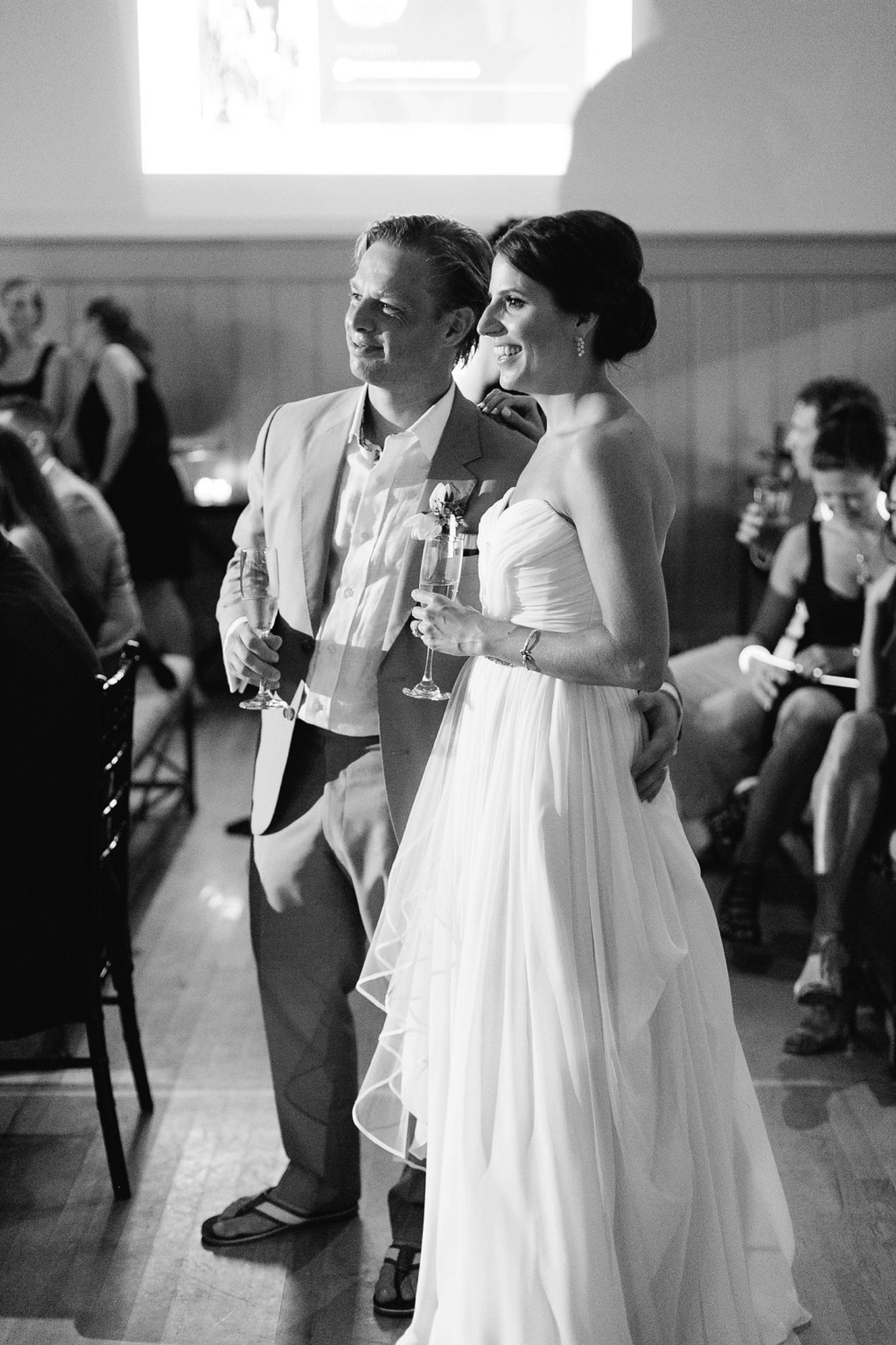 Classic black and white photo of bride and groom listening to speeches