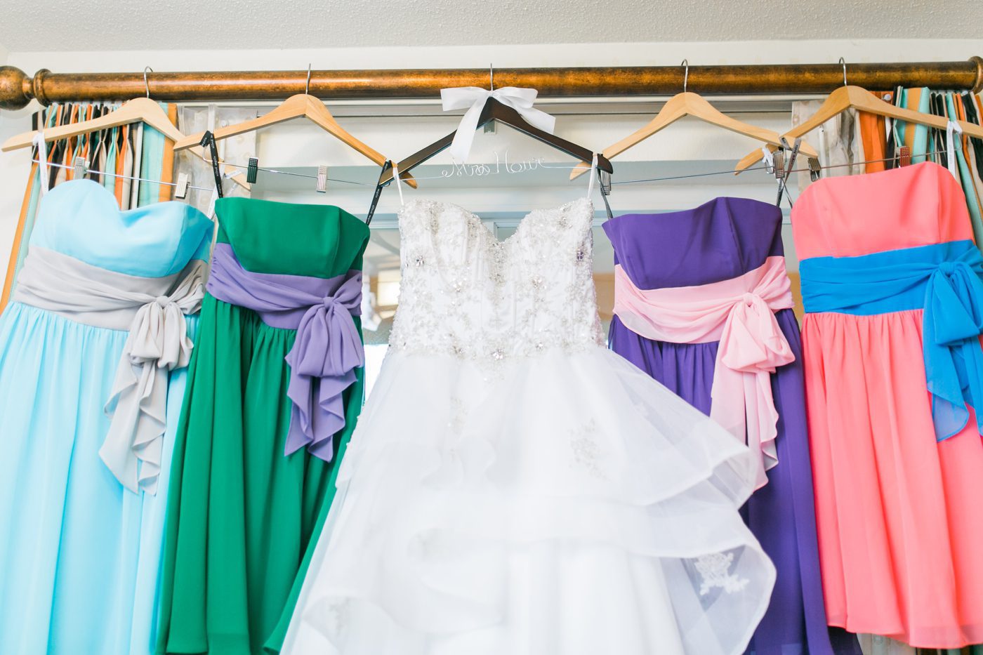 Disney themed bridesmaids dresses hanging in a window