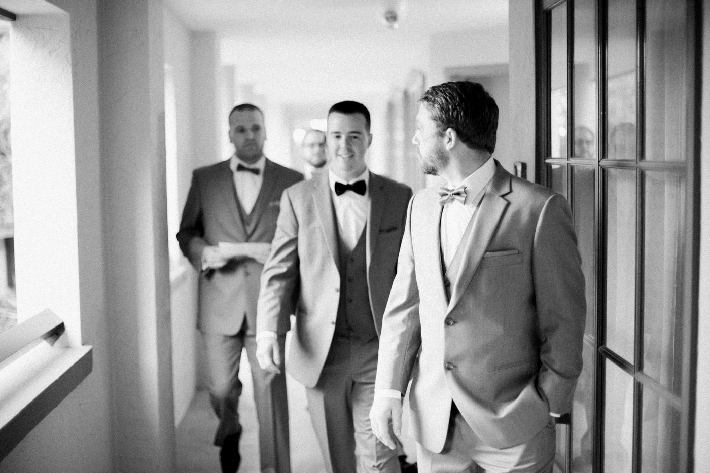Black and white photo of groom and groomsmen walking 
