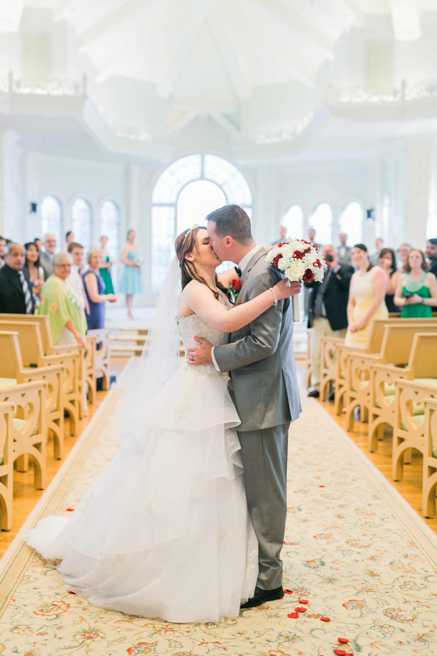 Disney World bride and groom kissing while walking down the aisle 