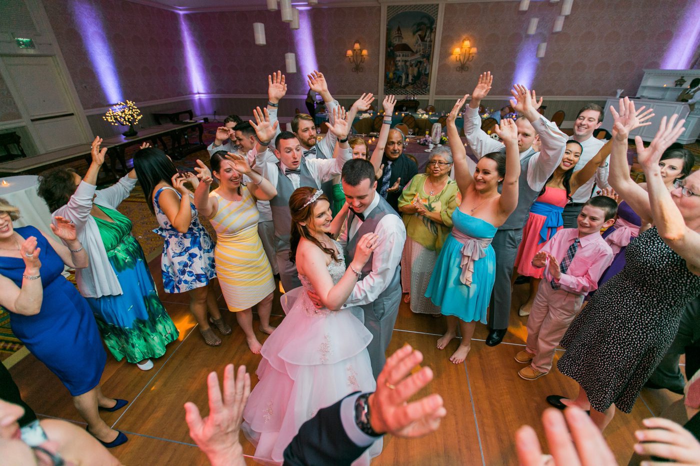 Guests dancing in a circle around the bride and groom at their Disney wedding