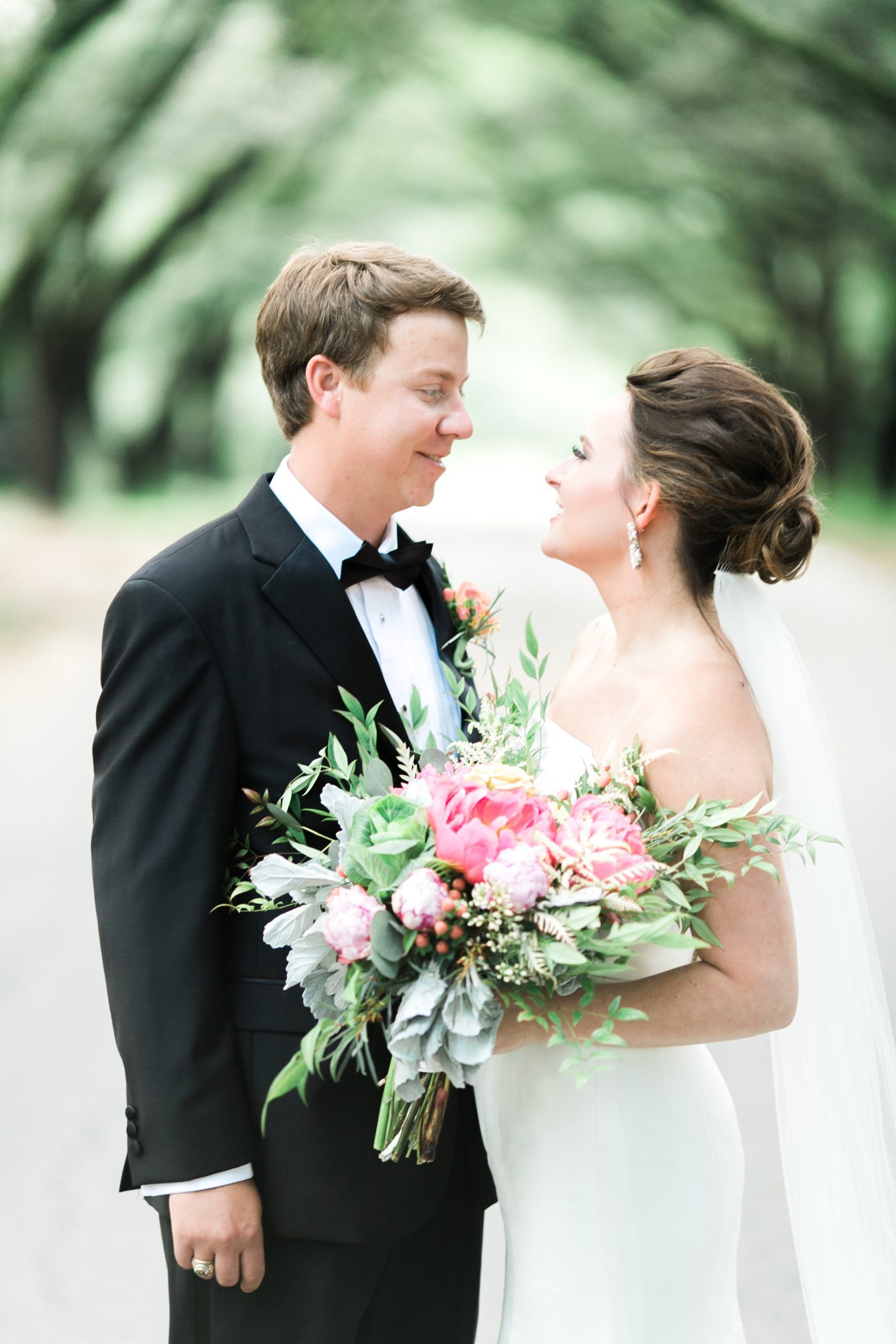 Wedding photo of bride and groom under avenue of oaks at the Drengaelen House in Hartsville. Photo by Charleston wedding photographer Catherine Ann Photography
