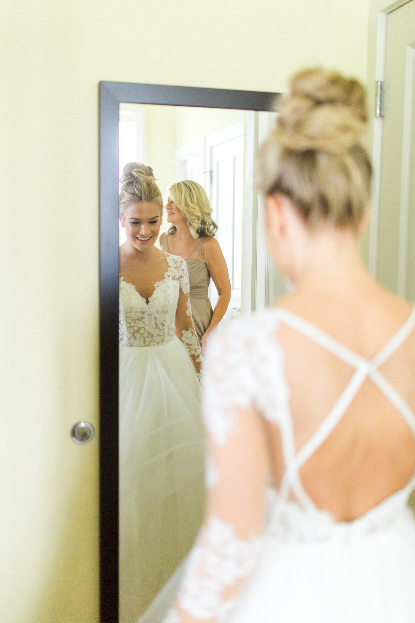 Bride seeing herself in a mirror in her Hayley Paige gown for the first time. Photo by Catherine Ann Photography