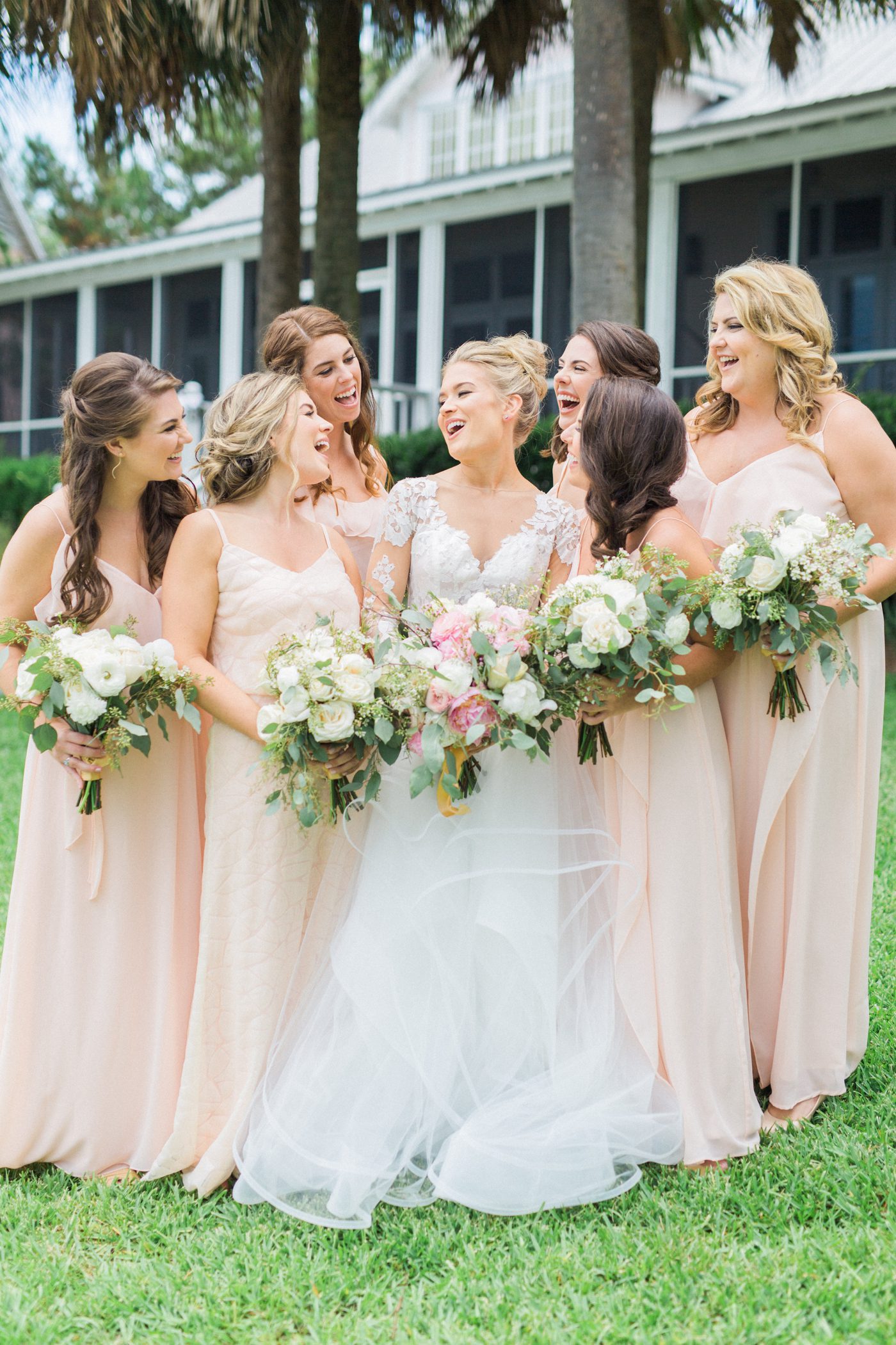 Candid picture of bride and bridesmaids laughing. Photo by Catherine Ann Photography