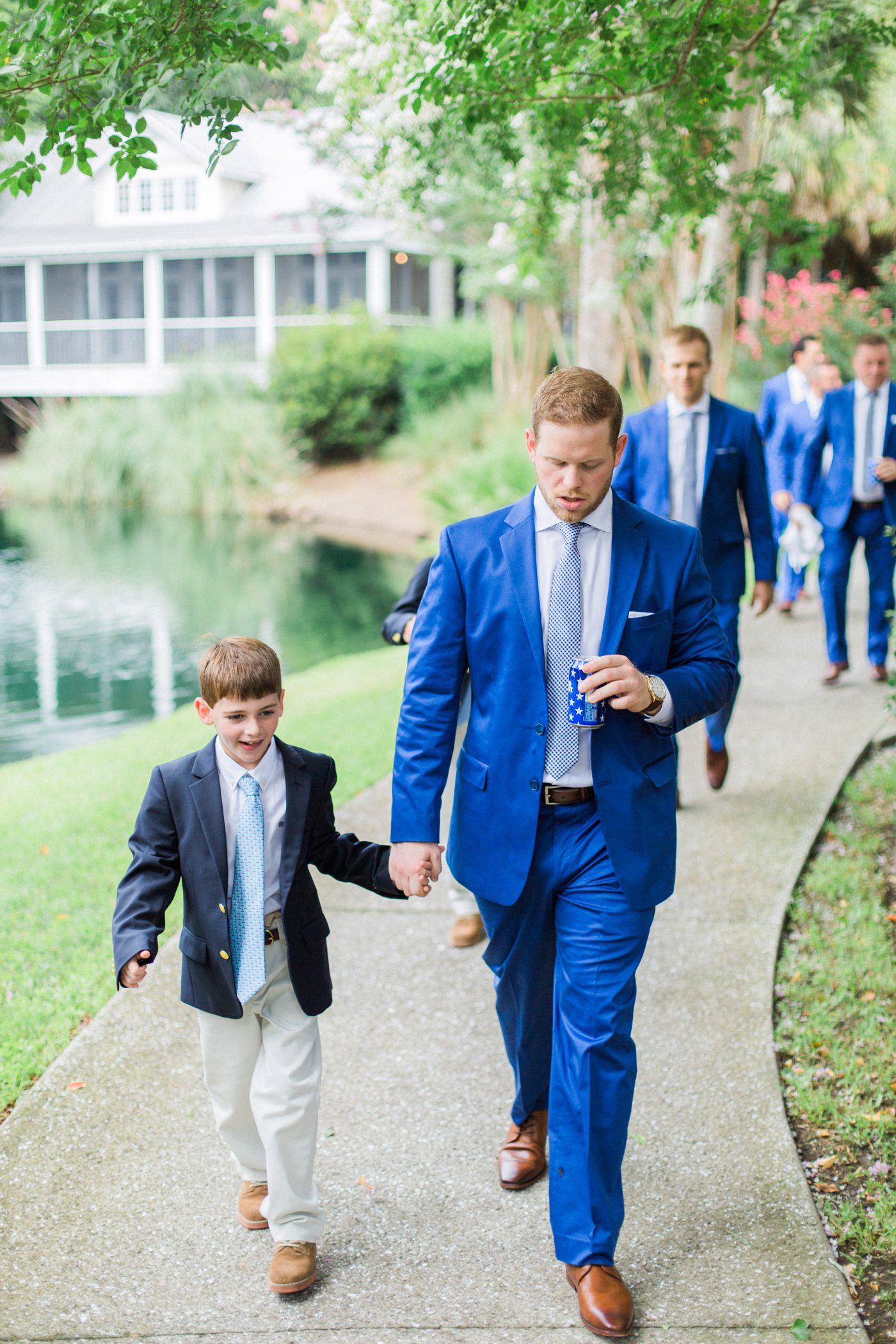 Groom walking with his ring bearer. Photo by Catherine Ann Photography