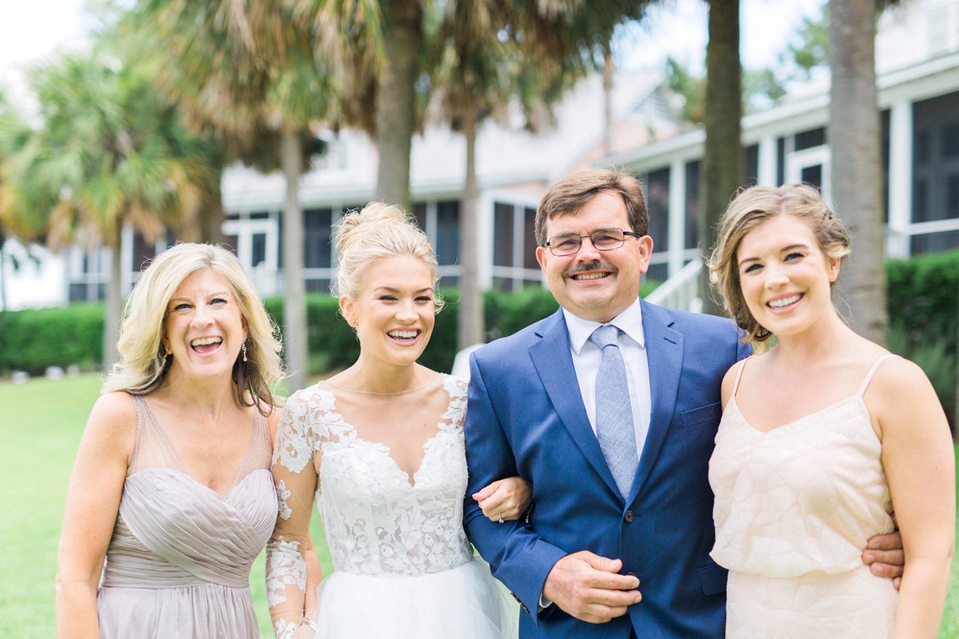 Candid family photo of the bride and her parents laughing together. Photo by Catherine Ann Photography