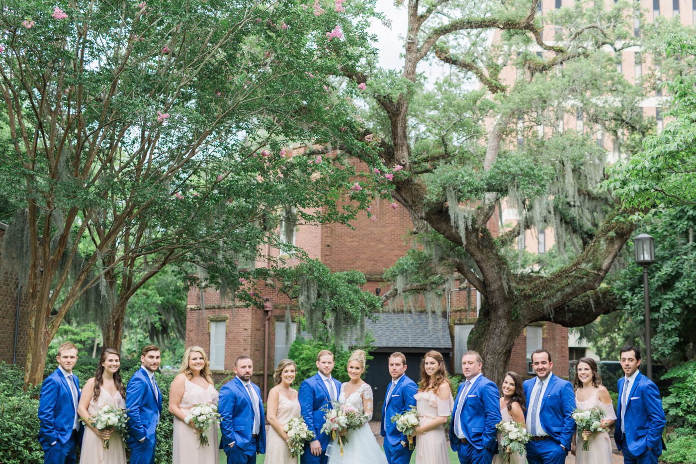 Bridal party photo under oak trees and spanish moss in Charleston. Photo by Catherine Ann Photography