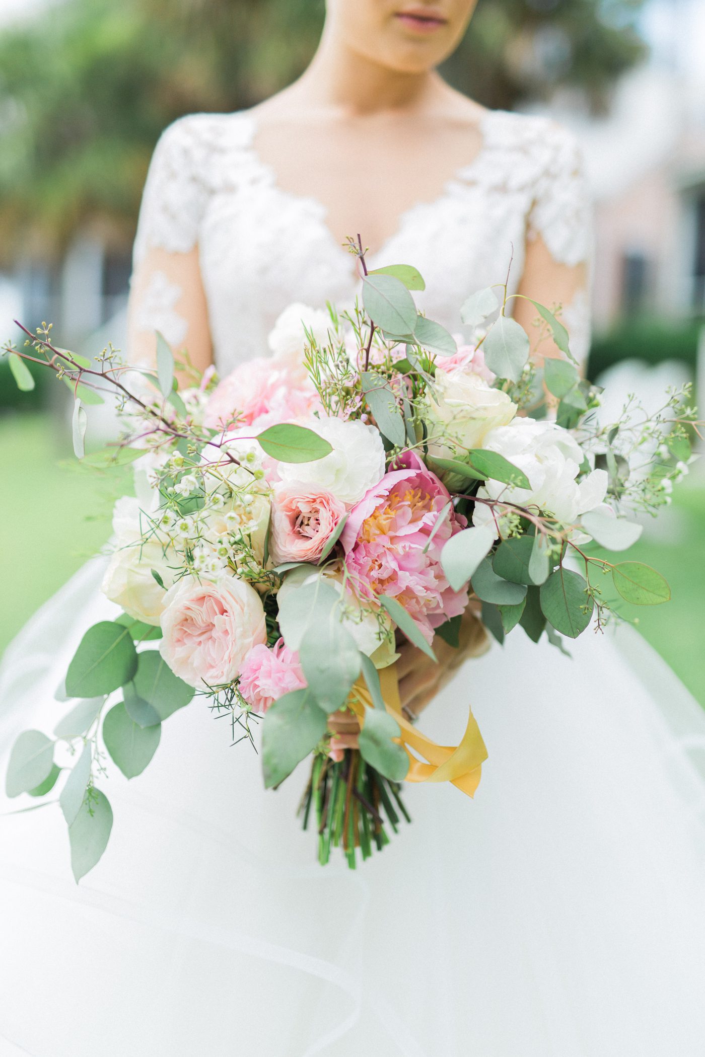 Outdoor bridal portrait in Charleston SC with pink green and white wedding bouquet. Photo by Catherine Ann Photography