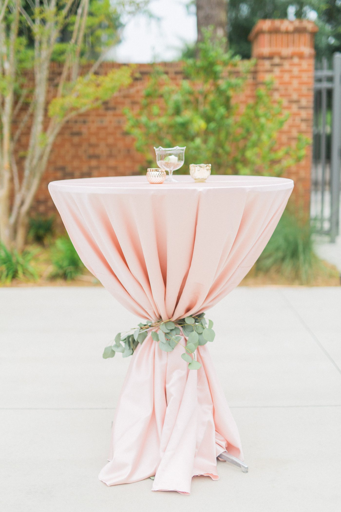 Pink table cloth tied with eucalyptus 