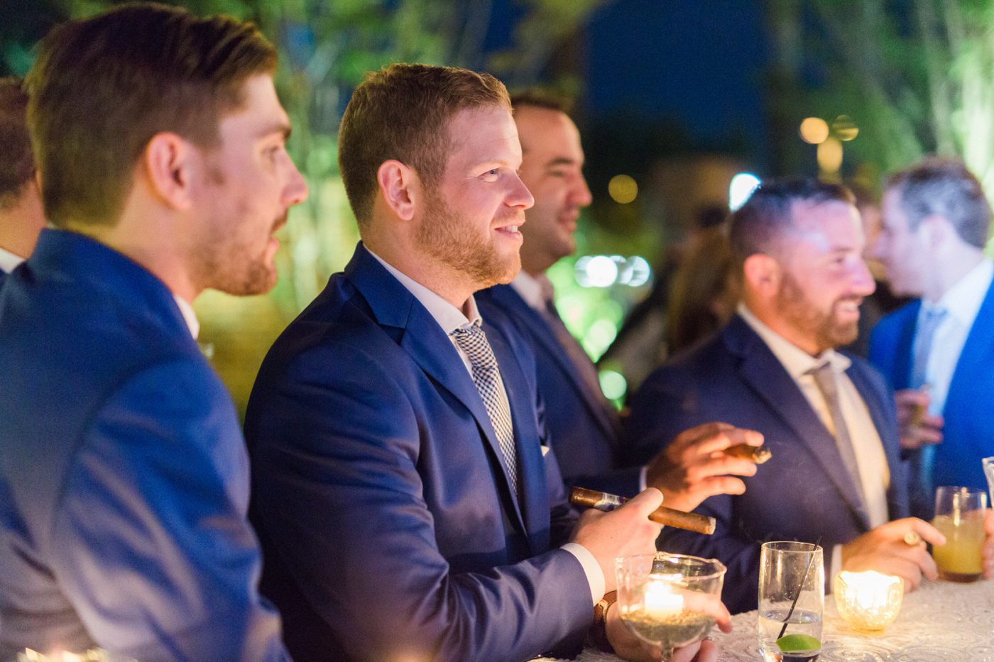 Candid image of groom smoking cigars with his groomsmen at the Cedar Room in Charleston