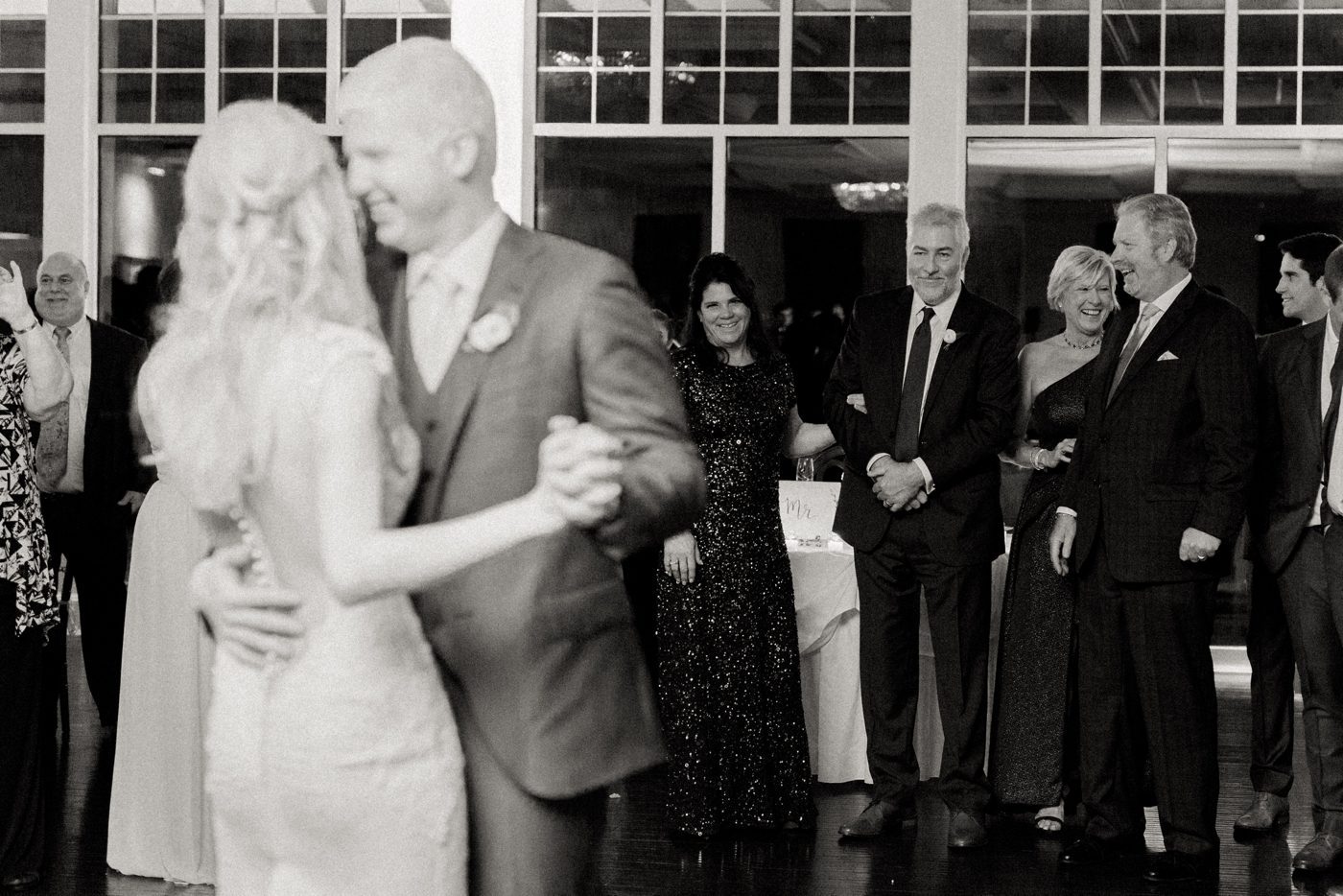 parents watching bride and groom dancing