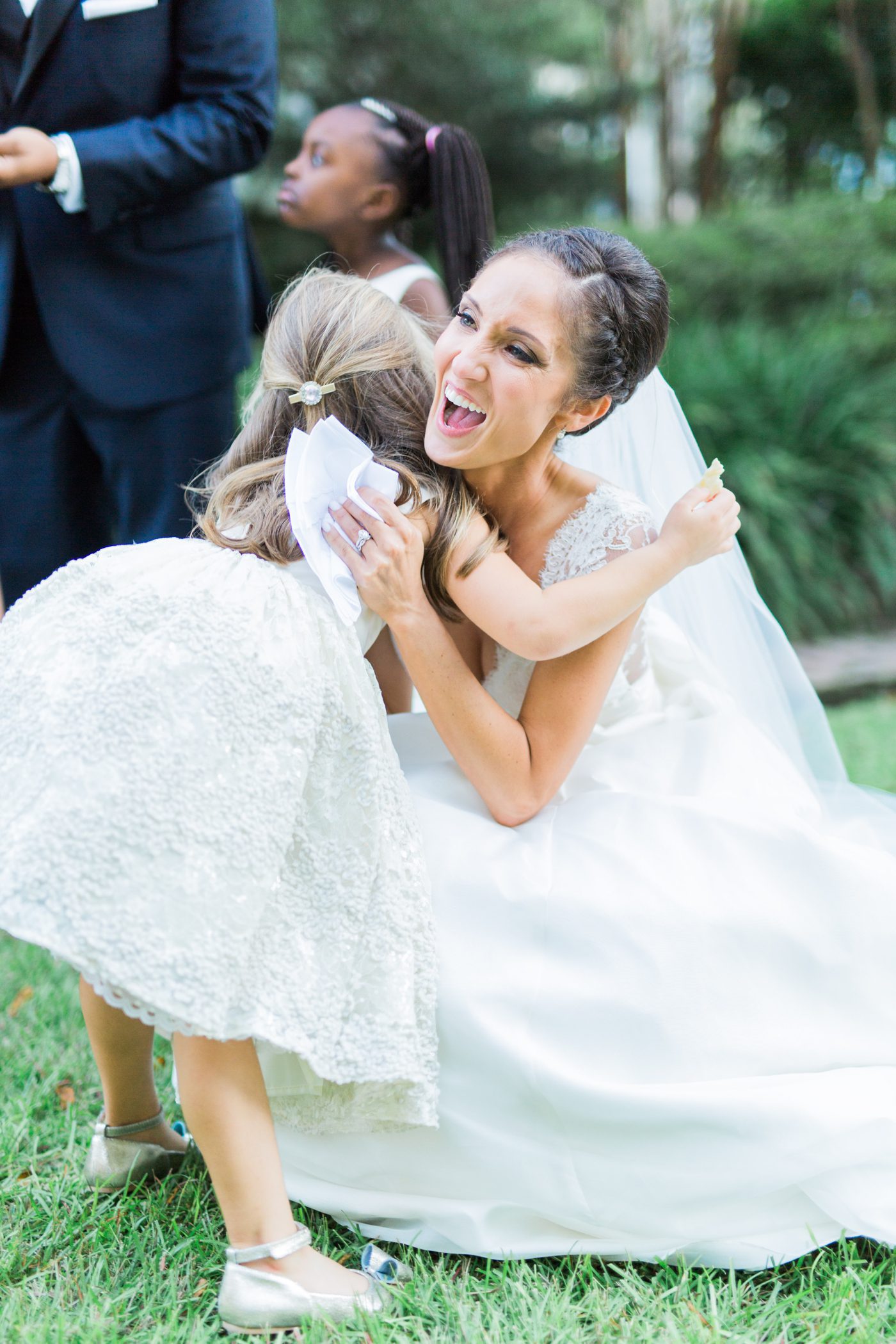 Adorable pic of flower girl hugging the bride at William Aiken House wedding by Catherine Ann Photography