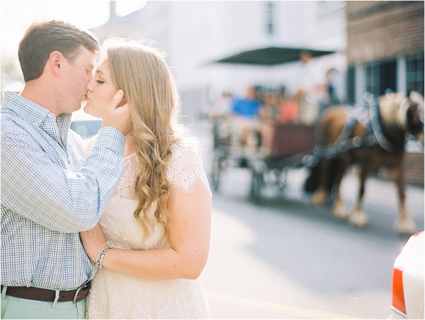 Creative engagement picture with horse and carriage in the background downtown Charleston SC
