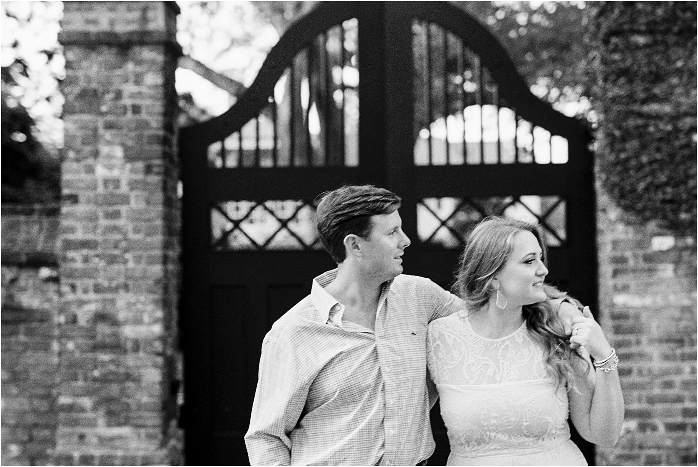 black and white engagement photo of couple walking in Charleston