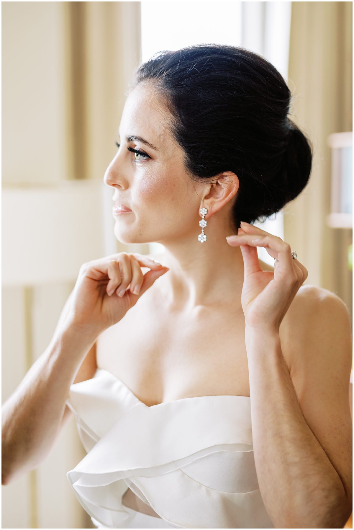 modern bridal look with low bun, ruffle gown and tear drop floral earrings