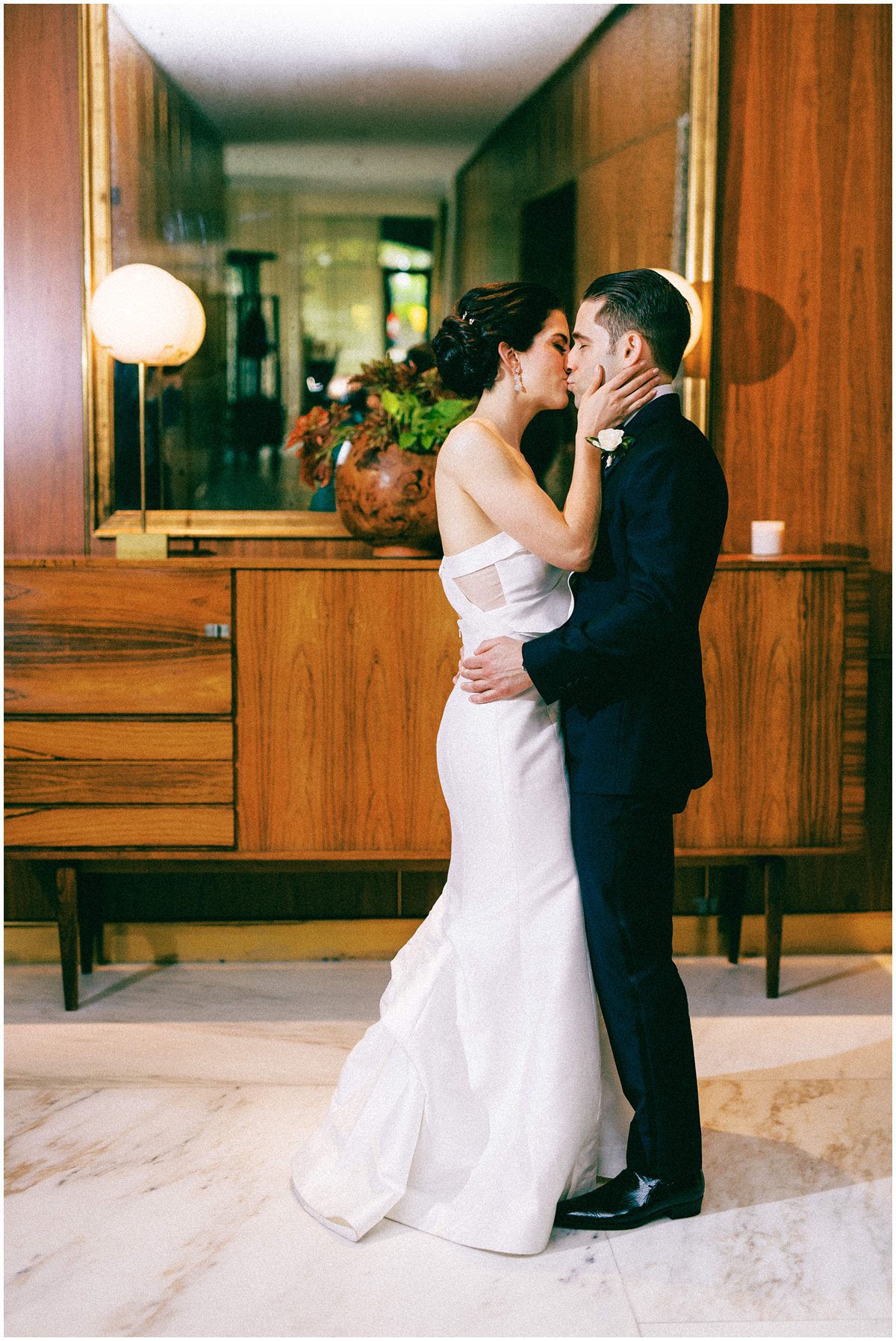 Bride and groom kissing in the hotel lobby at the Dewberry in Charleston