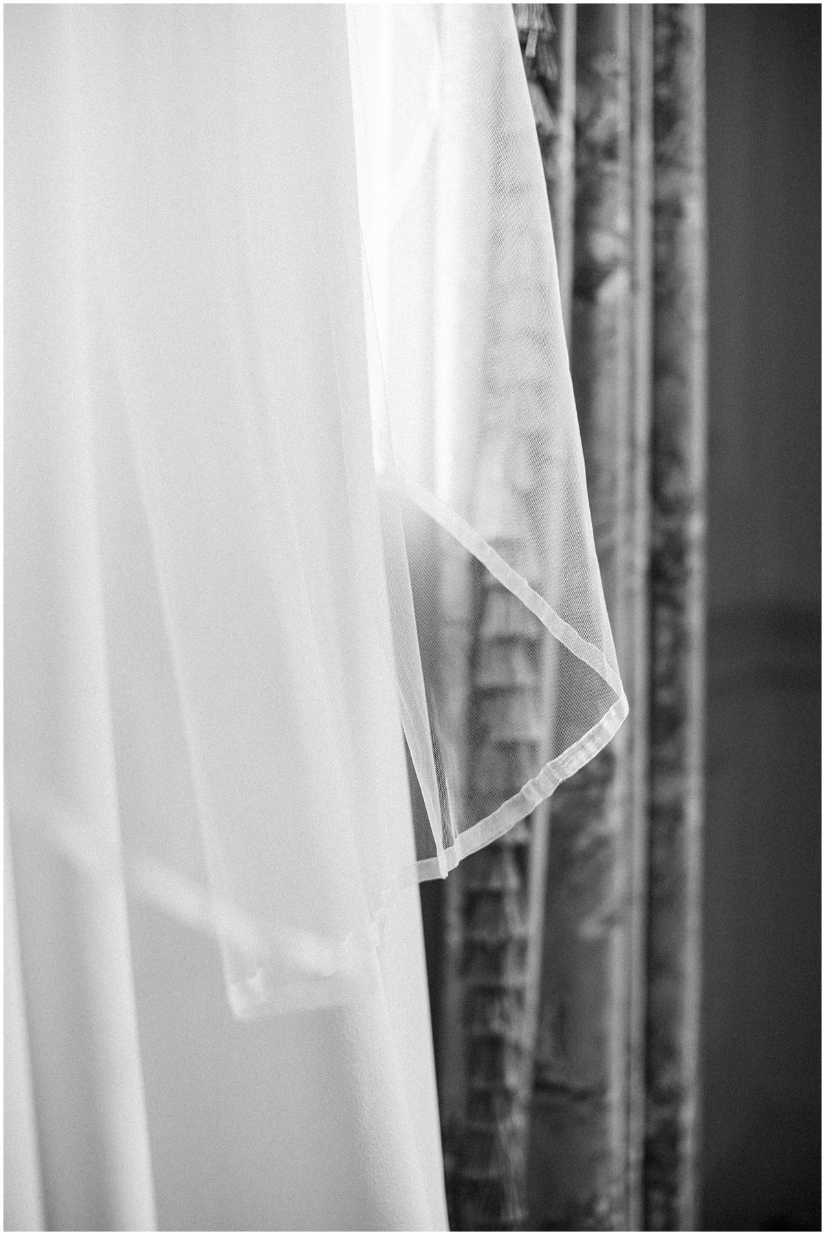 Black and white editorial wedding photo of brides veil
