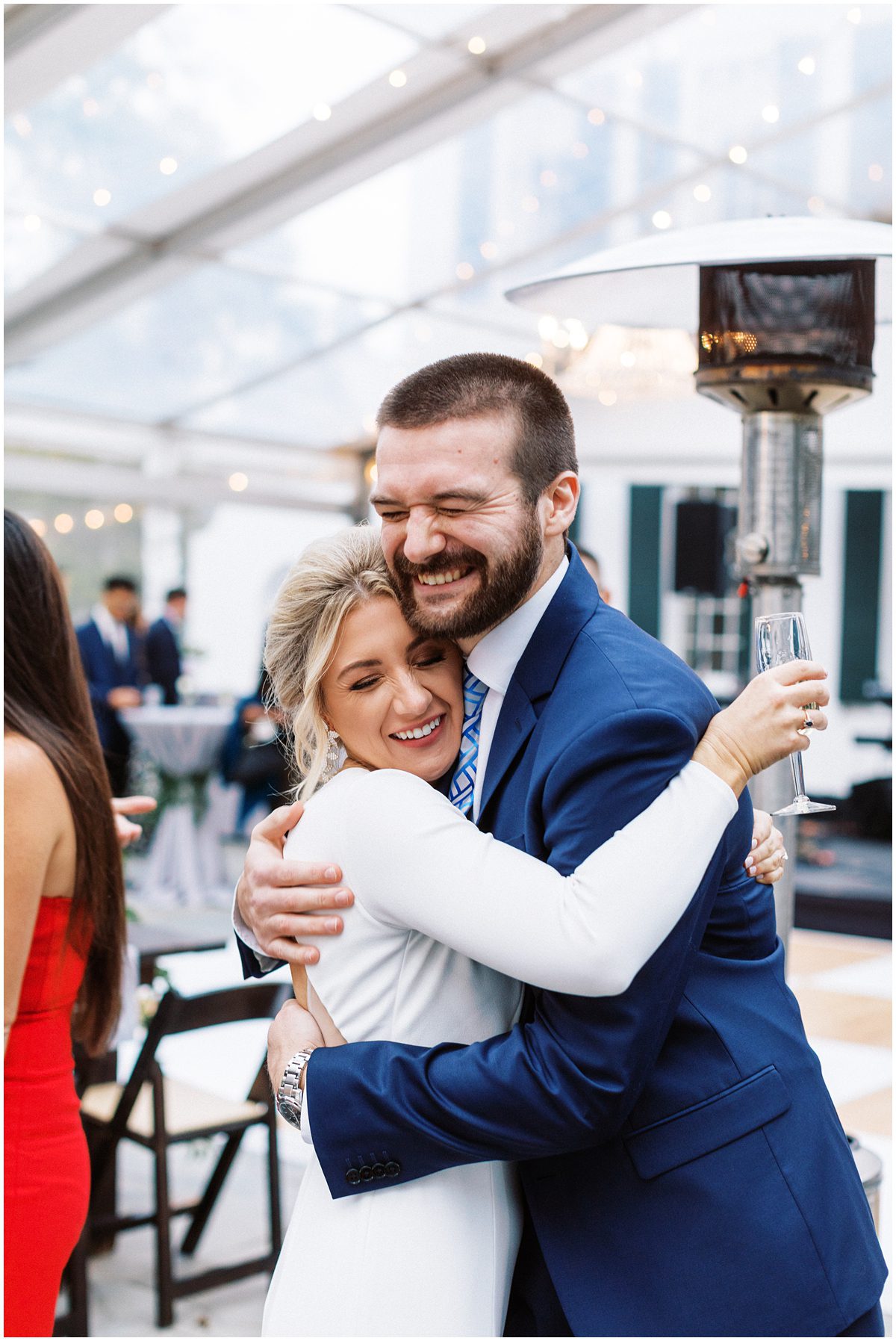 candid photo of bride hugging a guest at cocktail hour at Lowndes Grove