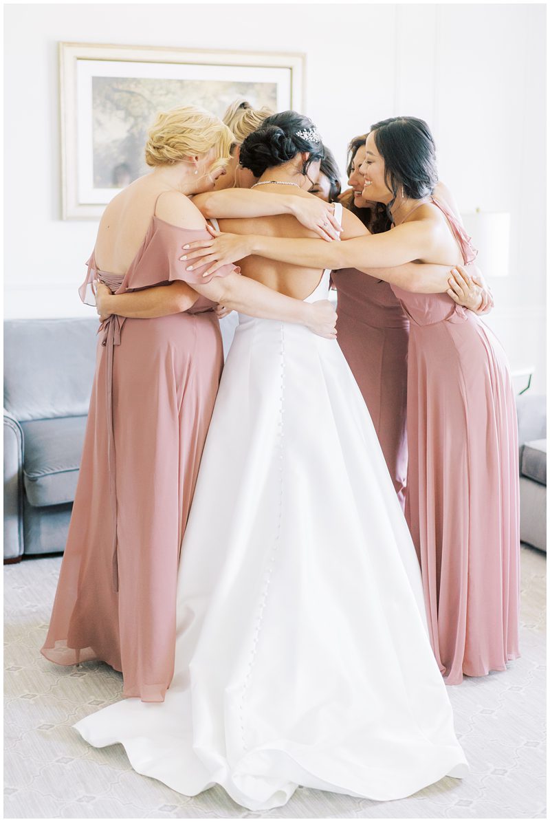 photo of bride and bridesmaids hugging 