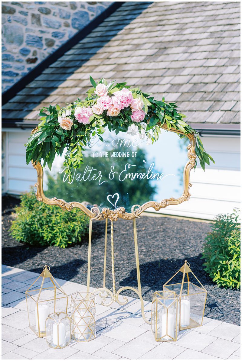 wedding ceremony sign on a mirror with flowers and candles
