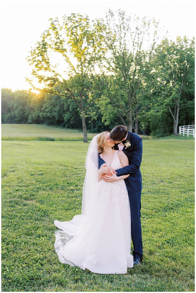 Wedding photo of bride and groom kissing at sunset at Bluestone Estate