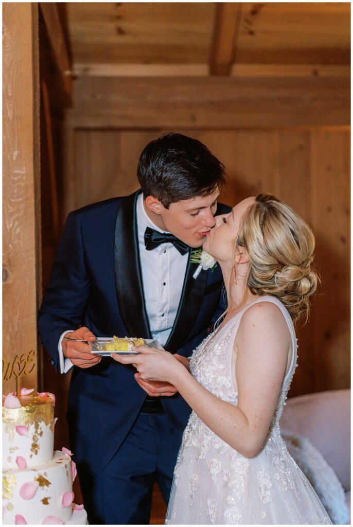 bride and groom kissing after cutting the cake