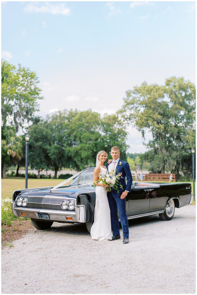 wedding photo of bride and groom with a vintage convertible car in Charleston