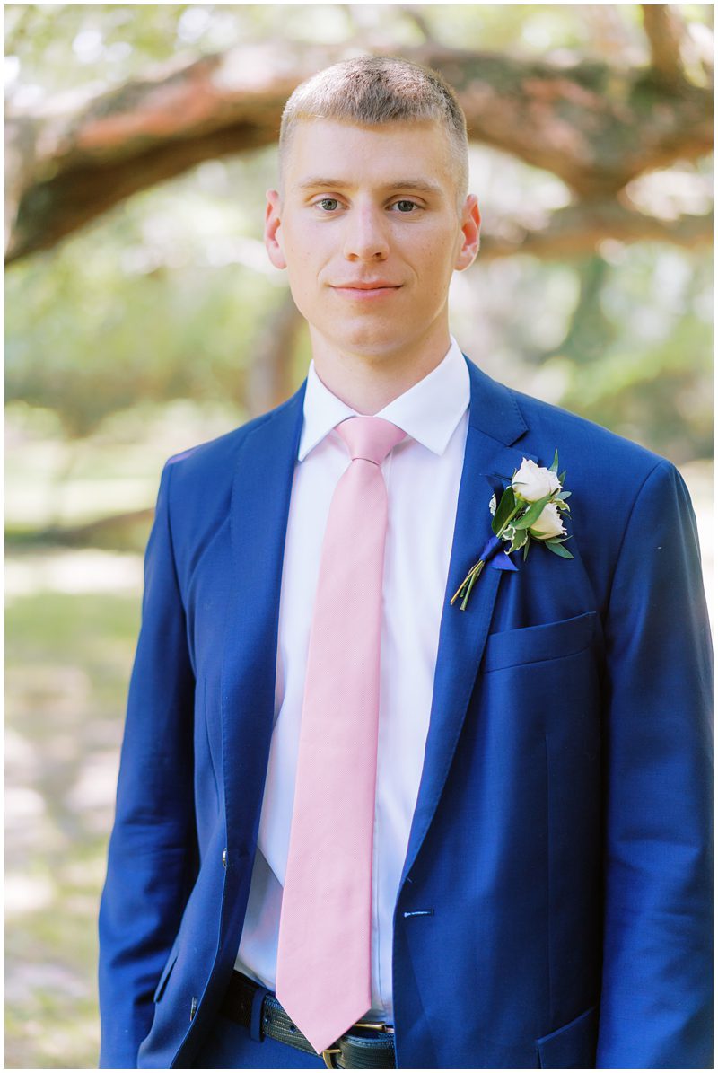 Groom wearing a bright blue suit and pink tie