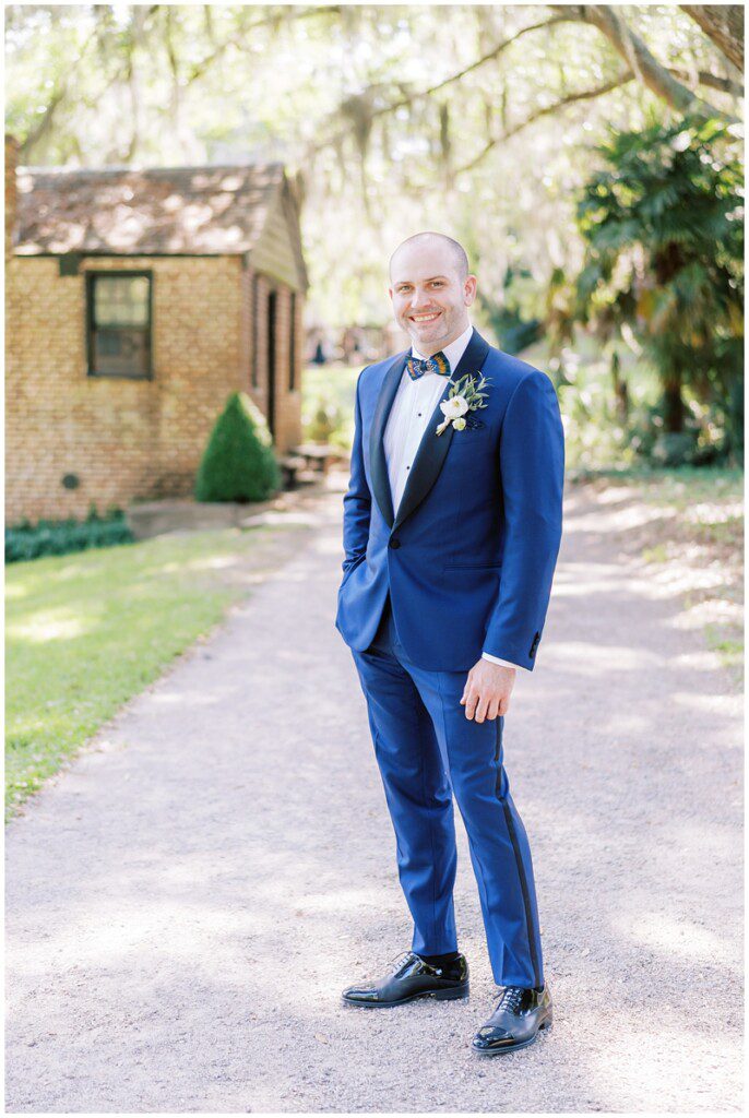Groom wearing a bright blue suit and brackish bowtie at Middleton Place