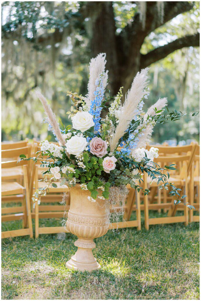 wedding ceremony aisle decor idea of flowers with pampas grass in an urn