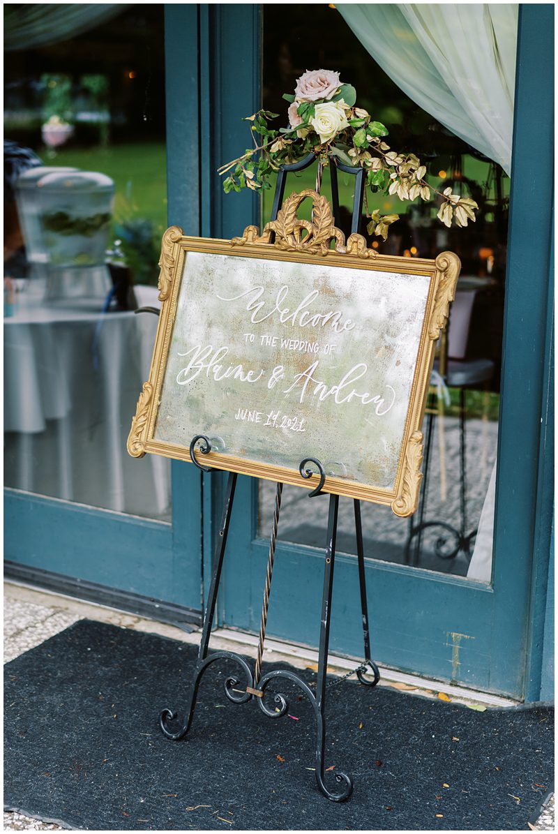 wedding ceremony decor idea of an antique gold framed mirror welcoming guests