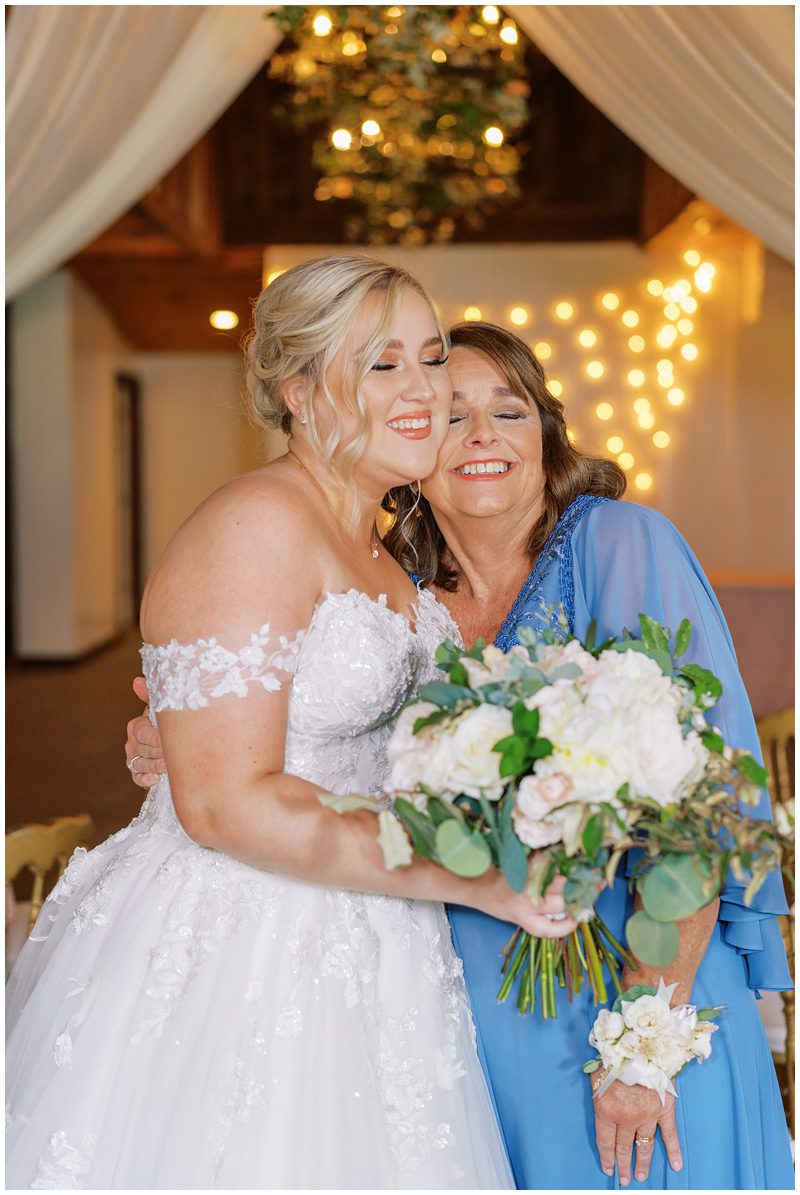 candid wedding photo of bride and mom hugging