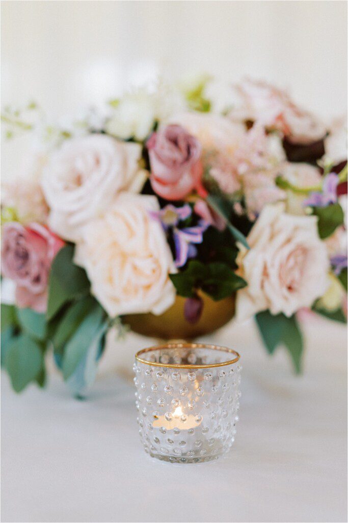 wedding reception decor with pink flowers and glass candles